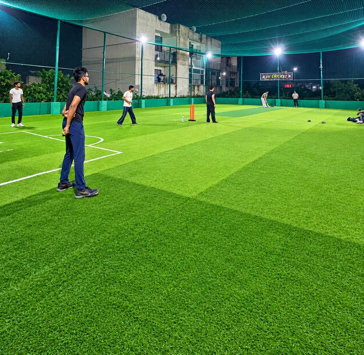 Players on the Arena Seven turf under floodlights